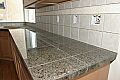 Granite tile on the countertops with slate backsplash and accent tile strip