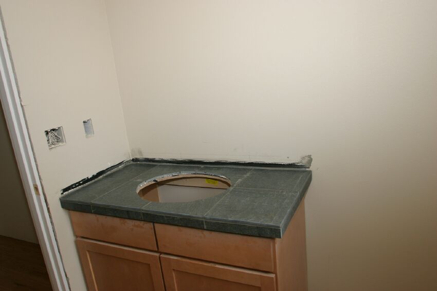 The powder room vanity uses the same green slate as the fireplace