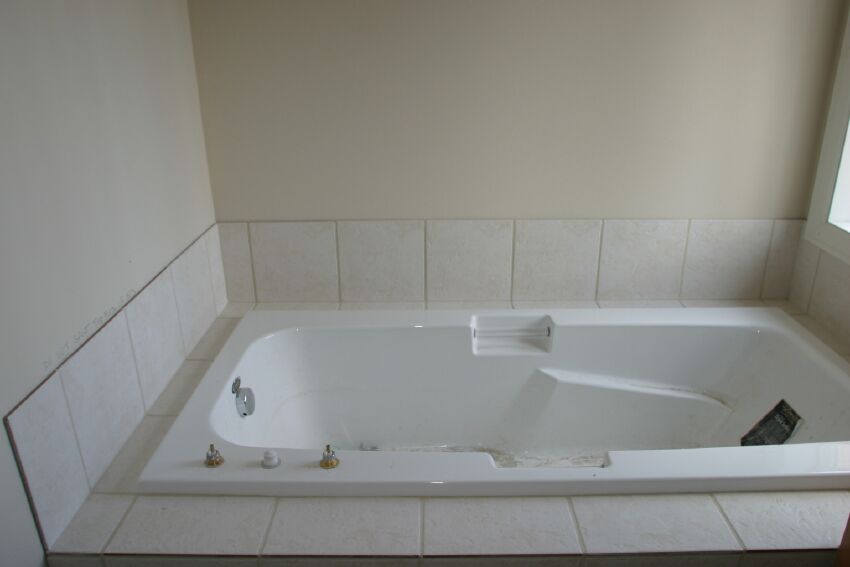 Slate tile surrounds the soaking tub in the master bath